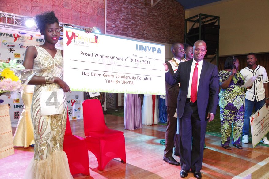 Tryphena Natukunda , left, a Ugandan living with HIV/ Aids the winner of the third annual Uganda Network of Young People Living with HIV beauty pageant at Golf Course Hotel Kampala, Uganda, Saturday Sept. 24, 2016. When she was younger, Tryphena Natukunda's mother discouraged her from swallowing her antiretroviral medicines among strangers or even distant relatives. Because she was suffering from AIDS, which can fuel stigmatization and invite harsh judgment, the mother wanted her child's condition kept a secret within the family. (AP Photo/Stephen Wandera)