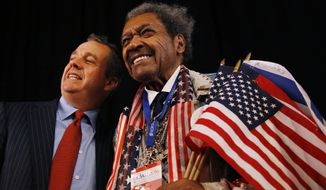 Boxing promoter Don King (right) poses with a guest before the presidential debate Monday at Hofstra University in Hempstead, New York. (Associated Press)