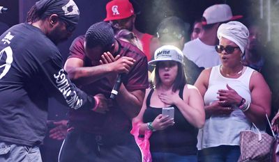 In this Sunday, Sept. 25, 2016, photo, Stanley “Flesh-N-Bone” Howse, of Bone Thugs-n-Harmony, center left, covers his face after he was hit with a drone onstage while performing during the High Life Music Festival in Victorville, Calif. (David Pardo/The Daily Press via AP)