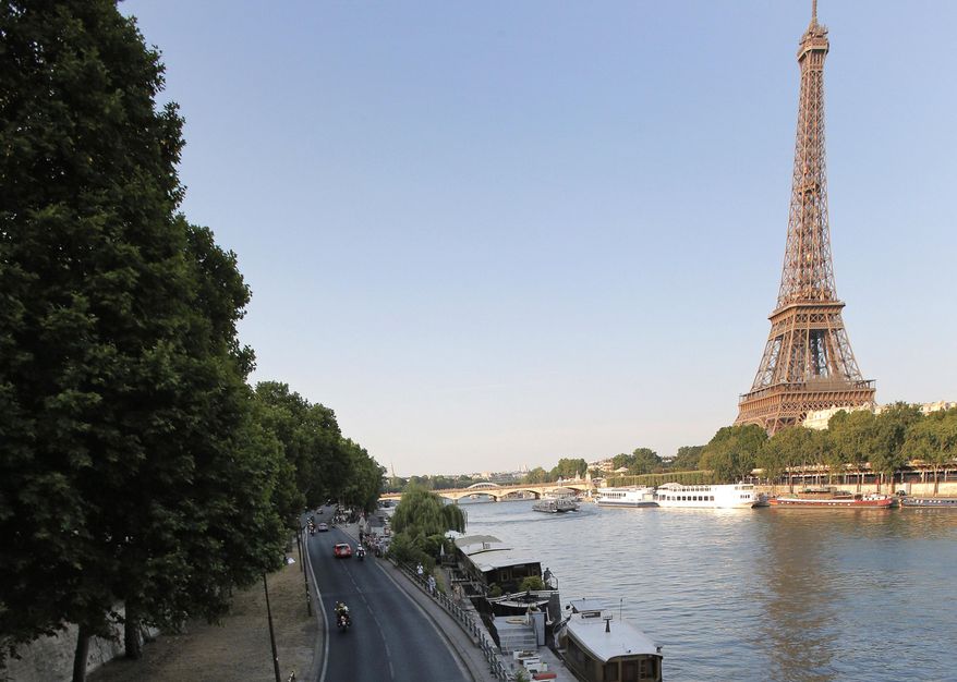 FILE - In this July 21, 2013 file photo shows the road along the Seine river, with the Eiffel Tower at right, in Paris. Paris City Hall has approved Monday Sept.26, 2016 a controversial plan to close down a stretch of highway that runs along the Seine River through central Paris and transform it into a pedestrian zone. It's part of Mayor Anne Hidalgo's push to fight Paris' exceptionally high pollution. (AP Photo/Christophe Ena, File)
