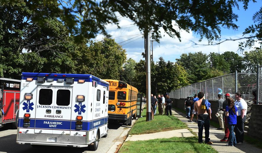 Police and rescue personnel work at the scene of a shooting on a school bus outside of the Wilson Academy alternative high school in Jackson, Mich., Monday, Sept. 26, 2016. Authorities said a 17-year-old student shot in the arm on the school bus outside of the southern Michigan school is expected to survive. (J. Scott Park/Jackson Citizen Patriot-Mlive.com via AP)