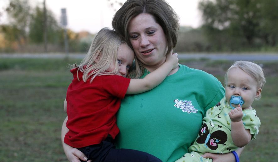 FILE - In this Nov. 11, 2010 file photo, Courtney Kemp, 27, holds her daughters Kaylee Kemp, 3, left, and Madisson Kemp, 9 months, in Jonesville, Courtney's husband Roy Wyatt Kemp, 27, died in the Deepwater Horizon oil rig explosion. The film, "Deepwater Horizon" is stirring mixed emotions for family members of the 11 men who died in the blast. While their reactions to the movie vary, many relatives share a hope that the film will remind people about the disaster's human toll. (AP Photo/Gerald Herbert)