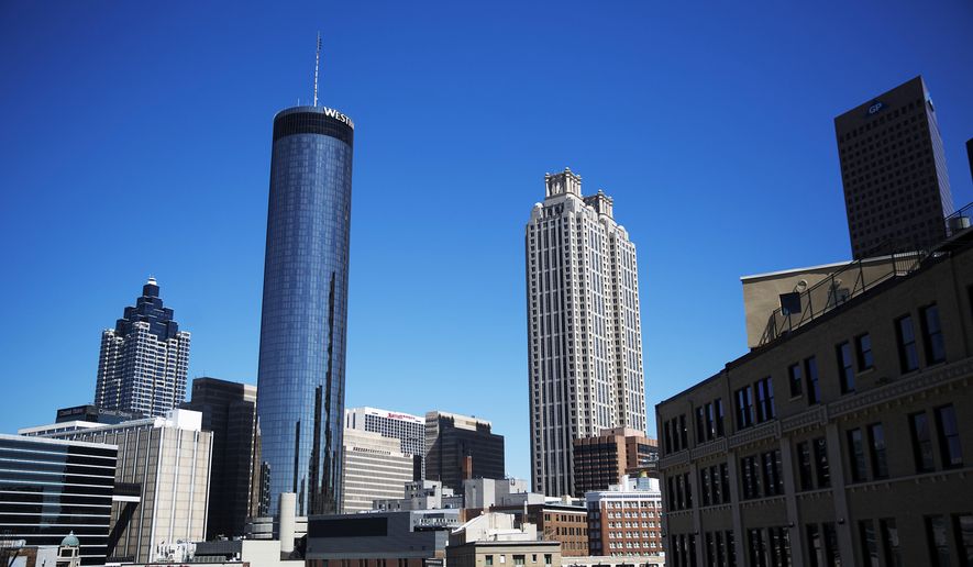The Westin hotel at left rises above downtown buildings in Atlanta, Wednesday, Sept. 28, 2016. An exit button inside the Westin hotel where a worker was found dead failed to work during an inspection, trapping multiple people who had to beat on the door to alert someone to let them out, a medical examiner found. The Fulton County Medical Examiner's Office has amended its autopsy for Carolyn Mangham to include the new details about the freezer exit button at the Westin Peachtree Plaza. (AP Photo/David Goldman)