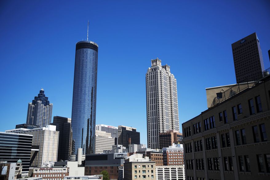 The Westin hotel at left rises above downtown buildings in Atlanta, Wednesday, Sept. 28, 2016. An exit button inside the Westin hotel where a worker was found dead failed to work during an inspection, trapping multiple people who had to beat on the door to alert someone to let them out, a medical examiner found. The Fulton County Medical Examiner's Office has amended its autopsy for Carolyn Mangham to include the new details about the freezer exit button at the Westin Peachtree Plaza. (AP Photo/David Goldman)
