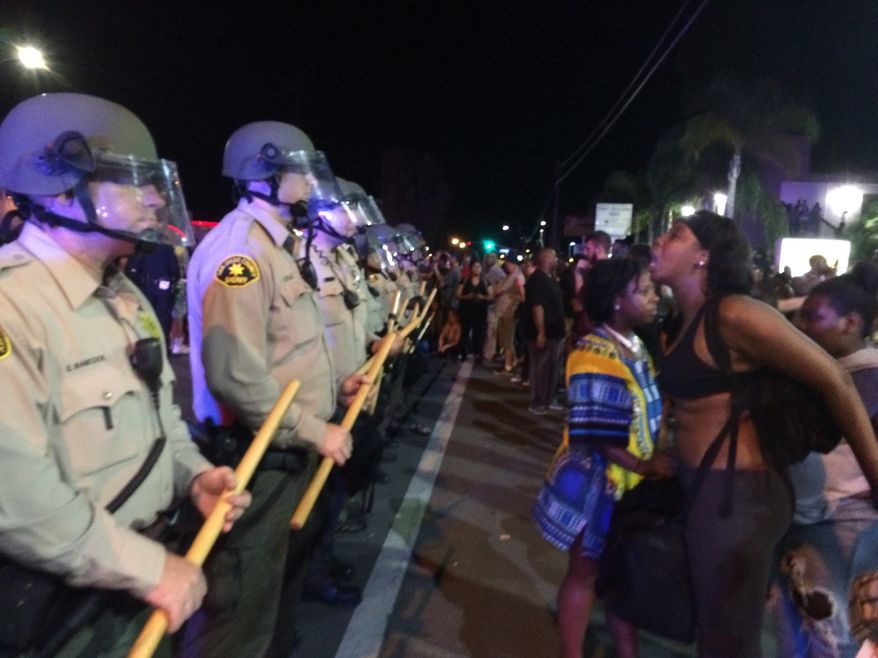 Demonstrators yell at police during a protest Wednesday, Sept. 28, 2016, in El Cajon, Calif. Dozens of demonstrators on Wednesday protested the killing of Alfred Olango, a Ugandan refugee shot by an officer after authorities said he pulled an object from a pocket, pointed it and assumed a "shooting stance." (AP Photo/Julie Watson)