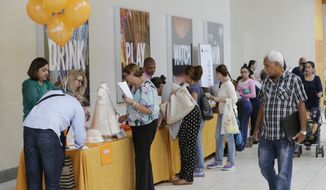 In this Tuesday, Oct. 6, 2015, file photo, job applicants fill out forms during a job fair at Dolphin Mall in Miami. (AP Photo/Wilfredo Lee, File)