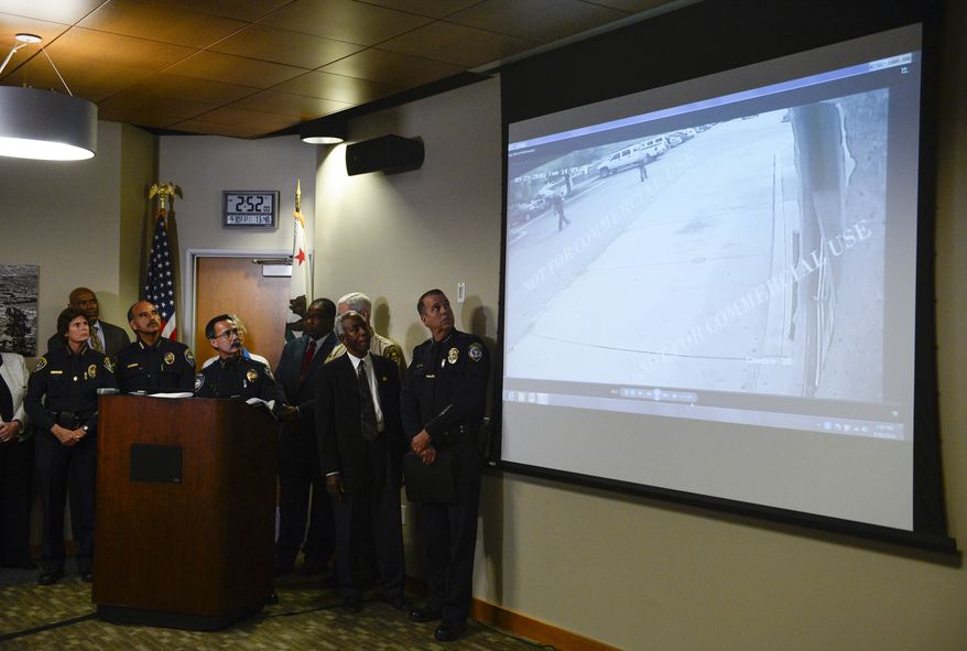 Authorities watch a video of the shooting scene at a news conference on Friday Sept. 30, 2016, in El Cajon, Calif, held to address the killing of Alfred Olango, a Ugandan refugee shot by an El Cajon police officer on Tuesday. The El Cajon police department released video footage of the shooting at the news conference.  (AP Photo/Denis Poroy)