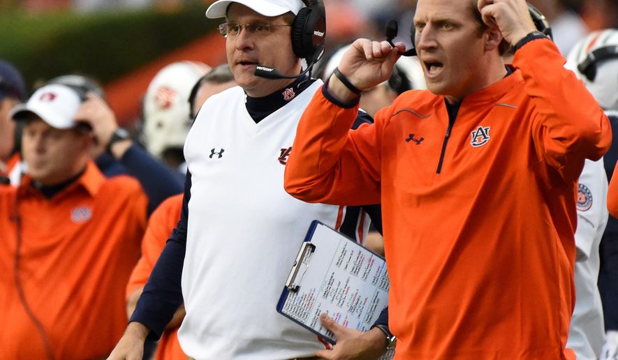 FILE - In this Nov. 21, 2015, file photo, Auburn coach Gus Malzahn, left, and offensive coordinator Rhett Lashlee, right, watch the action against Idaho during the first half of an NCAA football game in Auburn, Ala. Malzahn, who built his career on offensive play calling and creativity, has finally handed over the reins to let offensive coordinator Rhett Lashlee call plays. (AP Photo/Mark Almond, File)