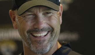Jacksonville Jaguars head coach Gus Bradley smiles as he answers questions at a media conference following an NFL practice session at the Allianz Park rugby stadium in London, Friday, Sept. 30, 2016. The Jacksonville Jaguars are due to play the Indianapolis Colts at Wembley stadium in London on Sunday in a regular season NFL game. (AP Photo/Alastair Grant)