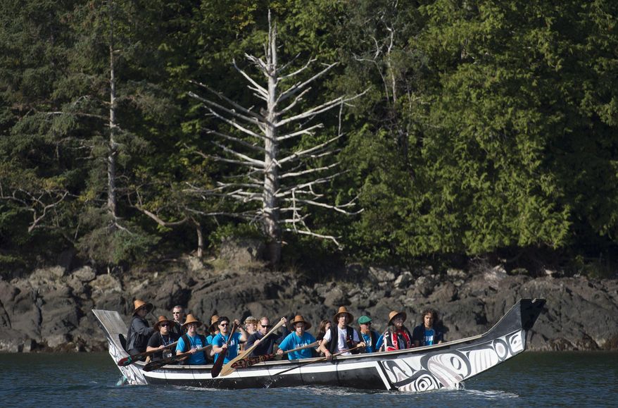 Britain's Prince William, the Duke of Cambridge, and Kate, the Duchess of Cambridge paddle with others in a traditional canoe in the waters of Haida Gwaii, British Columbia, Canada on Friday, Sept. 30, 2016. (Jonathan Hayward/The Canadian Press via AP)