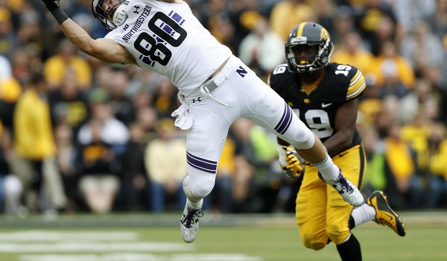 Northwestern wide receiver Austin Carr (80) catches a pass in front of Iowa defensive back Miles Taylor (19) during the second half of an NCAA college football game, Saturday, Oct. 1, 2016, in Iowa City, Iowa. Northwestern won 38-31. (AP Photo/Charlie Neibergall)