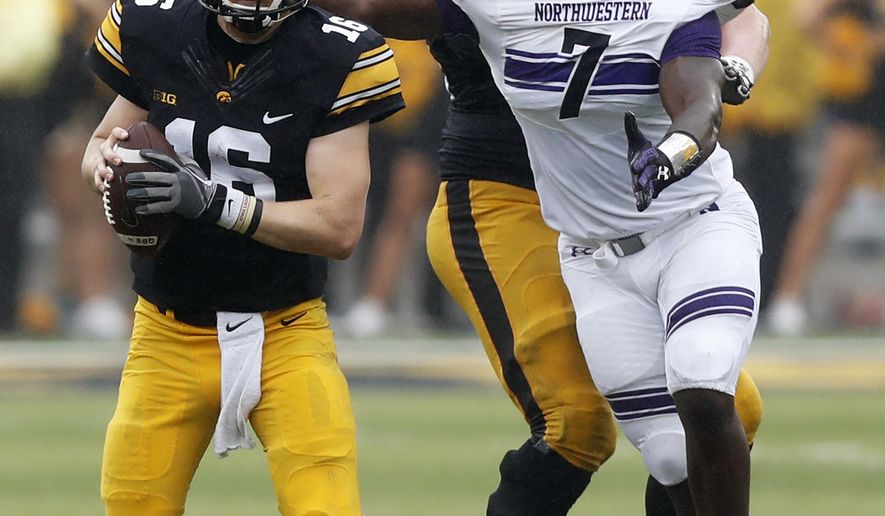 Iowa quarterback C.J. Beathard (16) runs from Northwestern defensive lineman Ifeadi Odenigbo (7) during the second half of an NCAA college football game, Saturday, Oct. 1, 2016, in Iowa City, Iowa. Northwestern won 38-31. (AP Photo/Charlie Neibergall)