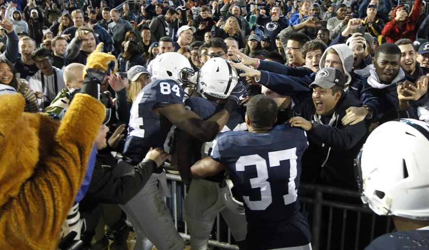 Penn State's Saquon Barkley (26) is mobbed by teammates after scoring the winning touchdown against Minnesota in overtime of an NCAA college football game in State College, Pa., Saturday, Oct. 1, 2016. (AP Photo/Chris Knight)