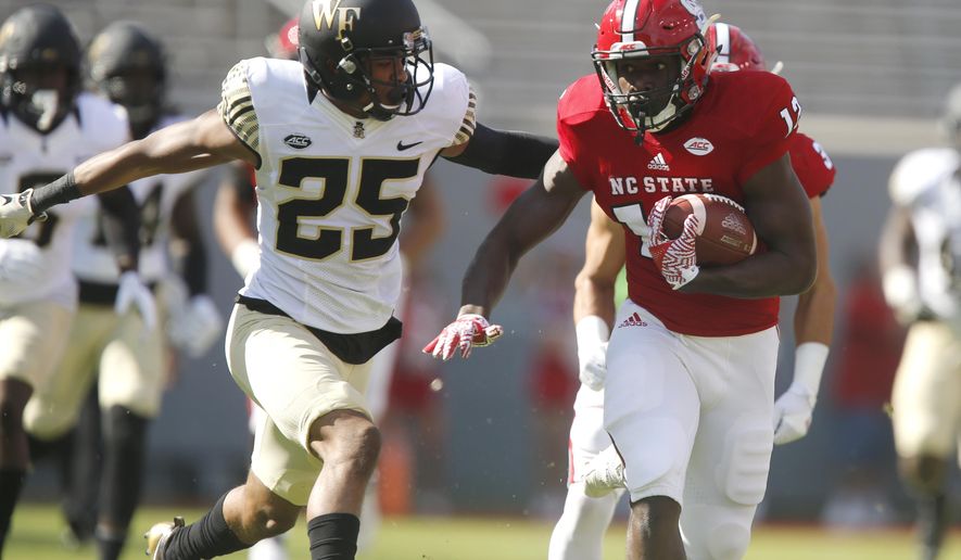 North Carolina State wide receiver Stephen Louis (12) tries to escape Wake Forest defensive back Brad Watson (25) after making a reception during the first half of an NCAA college football game in Raleigh, N.C., Saturday, Oct. 1, 2016. (Ethan Hyman/The News & Observer via AP)