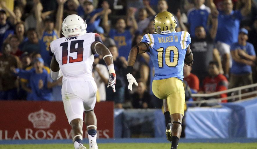 UCLA wide receiver Kenneth Walker III carries a pass in for a touchdown as outruns Arizona'a DaVonte' Neal pursuit during the first half of an NCAA college football game Saturday, Oct. 1, 2016, in Pasadena, Calif. (AP Photo/Reed Saxon)