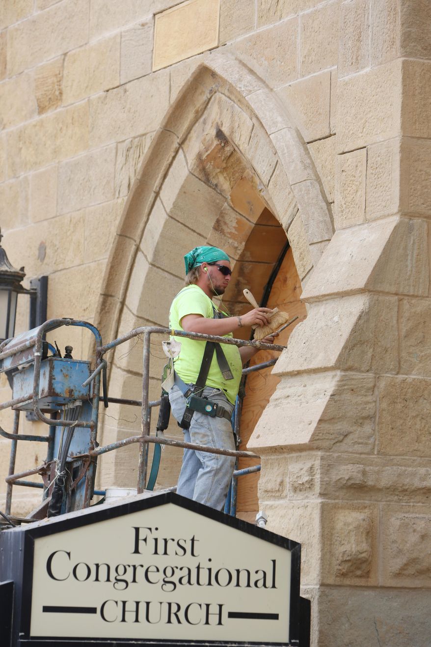 ADVANCE FOR SUNDAY OCT. 2 - In this Thursday Sept. 1, 2016 photo, Cavin Parker, with Bi-State Masonry of Rock Island, Ill., tuck-points around an archway to the entrance of First Congregational Church in downtown Burlington, Iowa. Fundraising for much-needed repairs and renovations to the church started last year, and the work itself has been going on through the summer. (John Lovretta/The Hawk Eye via AP)