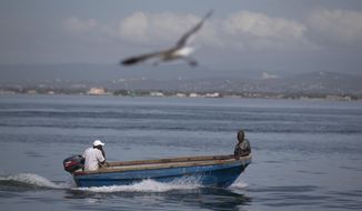 Fishermen sail on a boat at Port Royal in Kingston, Jamaica, Sunday, Oct. 2, 2016. Hurricane Mathew, one of the most powerful Atlantic hurricanes in recent history weakened a little on Saturday as it drenched coastal Colombia and roared across the Caribbean on a course that threatened Jamaica, Haiti and Cuba. (AP Photo/Eduardo Verdugo)