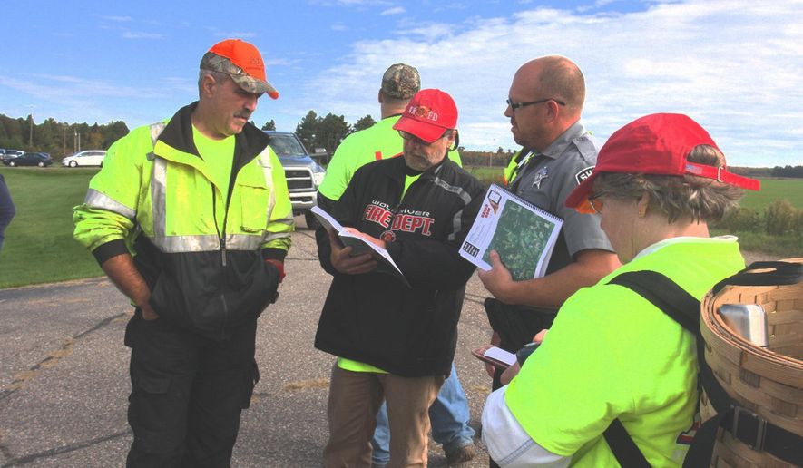 Langlade County Sheriff's Deputy D.J. Eldridge gathers with volunteers Sunday, Oct. 2, 2016, northeast of Antigo, Wisc., where a boy had become lost in a corn field late Saturday. The youngster was found safe and unharmed Sunday after a huge turnout of volunteers, fire departments and law enforcement in the area. (Fred Berner/Antigo Daily Journal via AP)