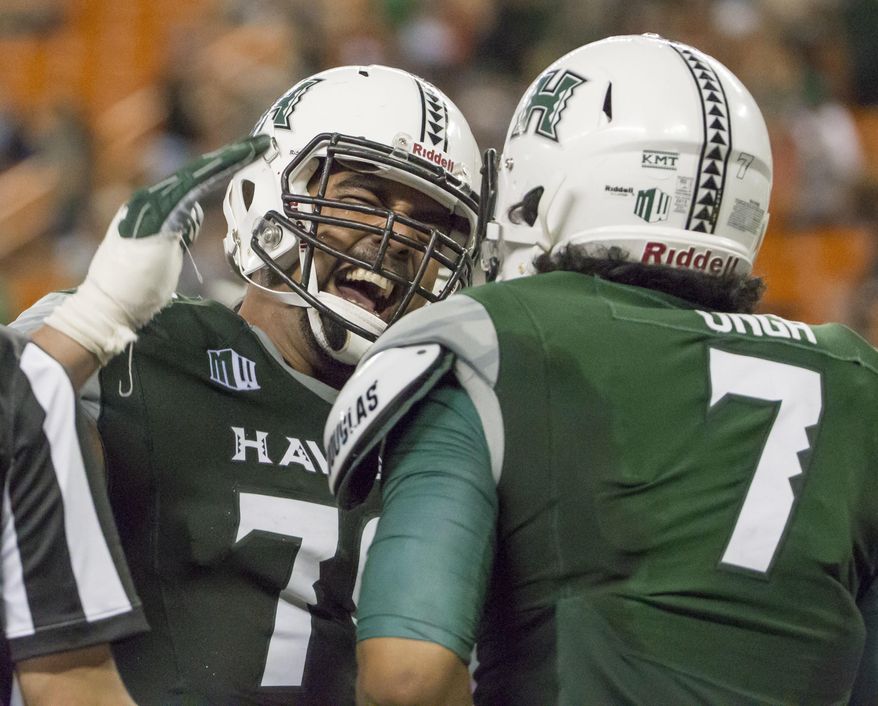 Hawaii offensive lineman Leo Koloamatangi, left, congratulates teammate tight end Metulsela Unga, right, for catching a pass for a touchdown during the second quarter of an NCAA college football game against Nevada, Saturday, Oct. 1, 2016, in Honolulu. (AP Photo/Eugene Tanner)
