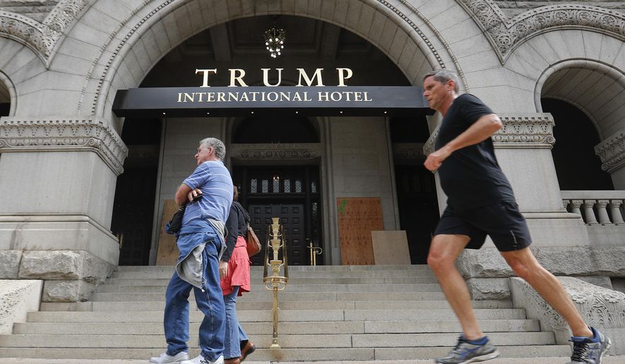 Plywood covers up graffiti at the entrance to the Trump International Hotel, Sunday, Oct. 2, 2016, in Washington. District of Columbia police said someone spray-painted the phrases “black lives matter” and “no justice no peace” on the front of the building on Saturday afternoon. (AP Photo/Pablo Martinez Monsivais)