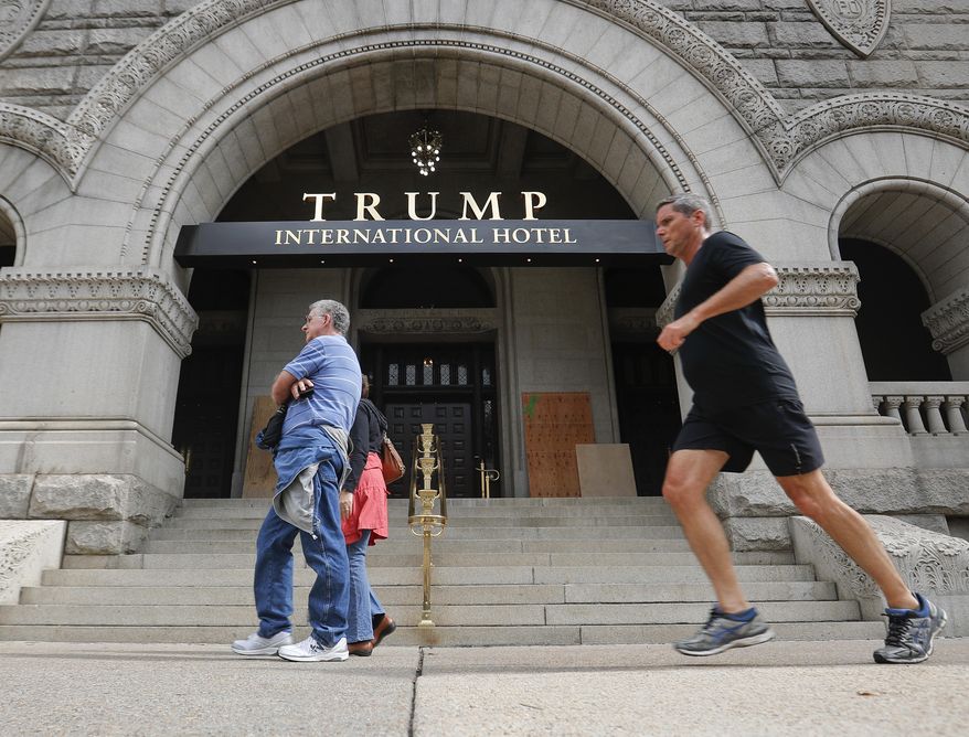 Plywood covers up graffiti at the entrance to the Trump International Hotel, Sunday, Oct. 2, 2016, in Washington. District of Columbia police said someone spray-painted the phrases “black lives matter” and “no justice no peace” on the front of the building on Saturday afternoon. (AP Photo/Pablo Martinez Monsivais)