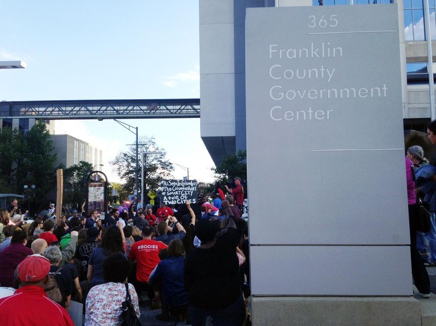Dozens of protesters upset about two fatal police shootings in Columbus, including the Sept. 14 shooting of Tyre King, a 13-year-old black teen, by a white Columbus police officer, rally outside the office of Franklin County Prosecutor Ron O'Brien, on Monday, Oct. 3, 2016, in Columbus, Ohio. The protesters are calling for an independent investigation of both shootings, changes to the way police shootings are investigated, and for O'Brien to meet with family members of both people who were shot and killed. (AP Photo/Ann Sanner)