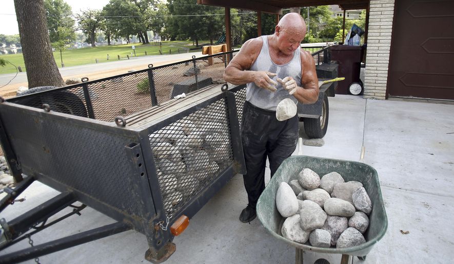 In this Sept. 7, 2016 photo, Alex Rothacker sorts through rocks as he transforms his yard into a desert, in Wildwood, Ill. He's a huge fan of the desert landscape. So much so he turned his green yard into a desert scape of rocks, gravel and cactuses. Rothacker admires the decor of the desert and describes it as clean and fresh. (Steve Lundy/Daily Herald, via AP)