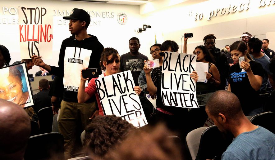 Black Lives Matter protesters demonstrate inside the board of Police Commissioners meeting in Los Angeles on Tuesday. Los Angeles police released surveillance video Tuesday showing an 18-year-old black suspect running from police while holding what appears to be a gun in his left hand just before he was fatally shot by officers in a death that has generated rowdy protests. (Associated Press)