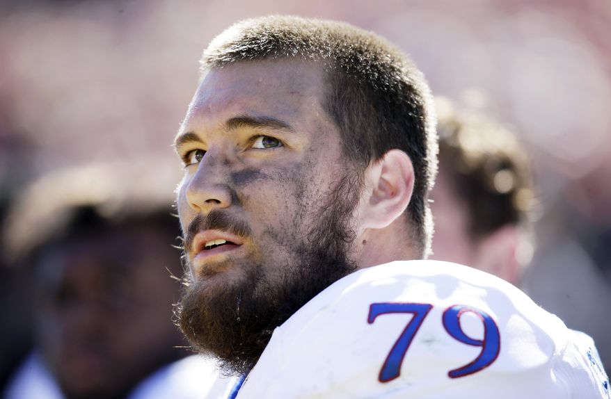 FILE - This Oct. 3, 2015 file photo shows Kansas offensive lineman Jordan Shelley-Smith on the bench during the second half of an NCAA college football game against Iowa State in Ames, Iowa. Jordan Shelley-Smith has decided to retire from football due to repeated concussions, the second player in the Big 12 to make that decision this week. (AP Photo/Charlie Neibergall, file)
