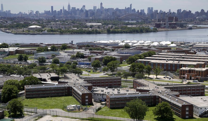 FILE - In a June 20, 2014, file photo, the Rikers Island jail complex stands in New York with the Manhattan skyline in the background. Two correction officers at New York’s Rikers Island have been assaulted by two inmates. It happened Tuesday evening, Oct. 4, 2016, at the Otis Bantum Correctional Center inside the jail complex. Both officers were taken to a hospital, where they were treated and released. (AP Photo/Seth Wenig, File)
