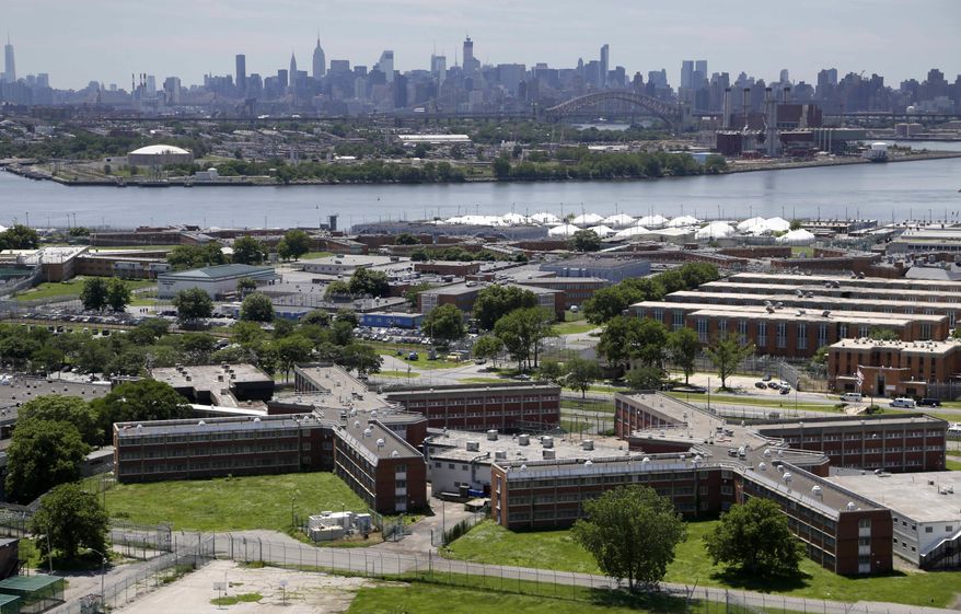 FILE - In a June 20, 2014, file photo, the Rikers Island jail complex stands in New York with the Manhattan skyline in the background. Two correction officers at New York’s Rikers Island have been assaulted by two inmates. It happened Tuesday evening, Oct. 4, 2016, at the Otis Bantum Correctional Center inside the jail complex. Both officers were taken to a hospital, where they were treated and released. (AP Photo/Seth Wenig, File)