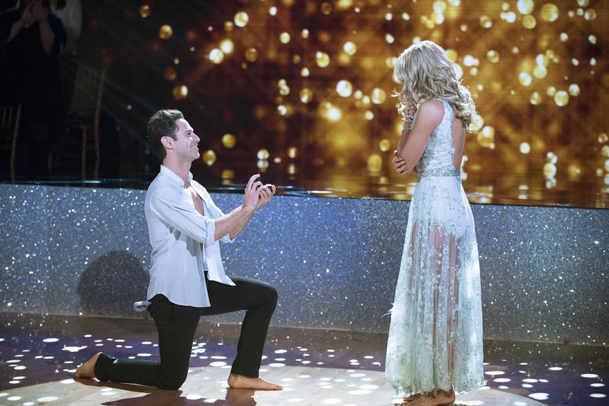 In this image released by ABC, Sasha Farber, left, proposes to Emma Slater during a broadcast of the celebrity dancing competition series, "Dancing with the Stars," in Los Angeles. The pair kicked off the show with a dance to Bruno Mars’ “Just The Way You Are.” Afterward, Farber told Slater that he’s “wanted to do this for such a long time” before revealing a ring. Slater quickly agreed and the couple was joined on stage by the rest of the cast. (Eric McCandless/ABC via AP)