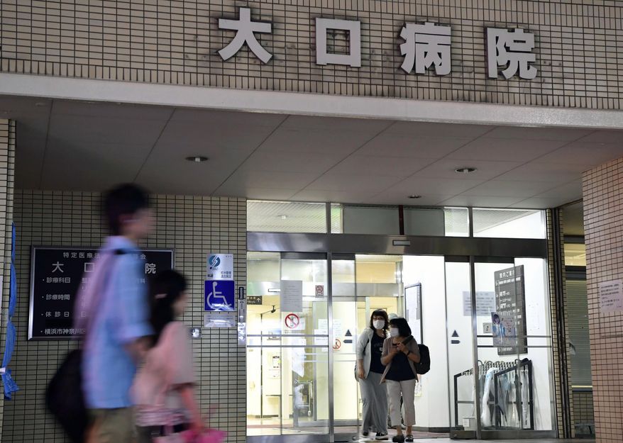 In this Sept. 29, 2016 photo, people pass by Oguchi Hospital in Yokohama, near Tokyo. Authorities in Japan are investigating the poisoning deaths of two elderly patients at the hospital specializing in terminal-stage care. Oguchi Hospital has had a higher death rate in recent months, sparking speculation that the poisoning may have been systematic and more widespread. (Iori Sagisawa/Kyodo News via AP)