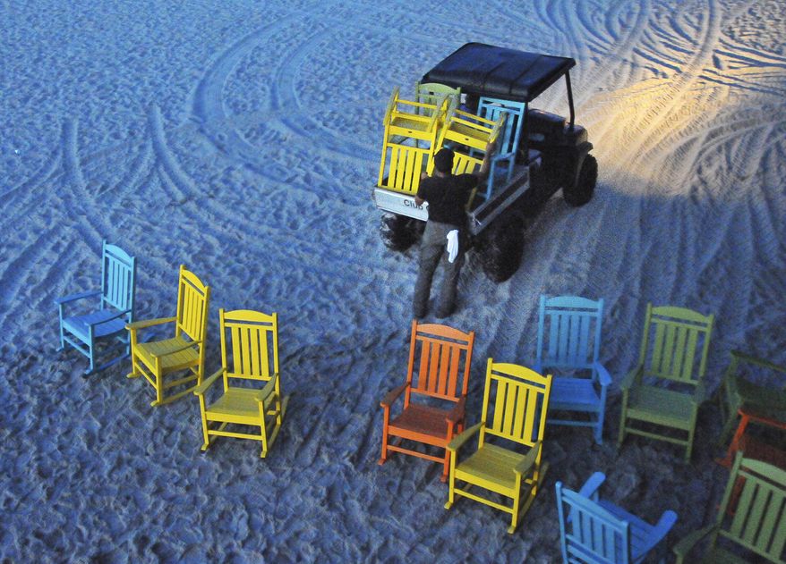 Workers start before dawn removing umbrellas and the colorful rocking chairs that line the Cocoa Beach Pier, moving them to a safer location as Hurricane Matthew approaches, Wednesday, Oct. 5, 2016, in Cocoa Beach, Fla. (Malcolm Denemark/Florida Today via AP)