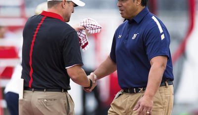 FILE - In this Nov. 27, 2015, file photo, Houston&#39;s head coach Tom Herman, left, and Navy&#39;s head coach Ken Niumatalolo shake hands on the field before an NCAA college football game between Houston and Navy, in Houston, Texas. Navy coach Niumatalolo offered a unique strategy when asked his thoughts on defending Houston’s high-powered offense Saturday.  “We’re trying to petition to the NCAA to see if we can play 15 guys on the field,” Niumatalolo said. (AP Photo/Juan DeLeon, File)