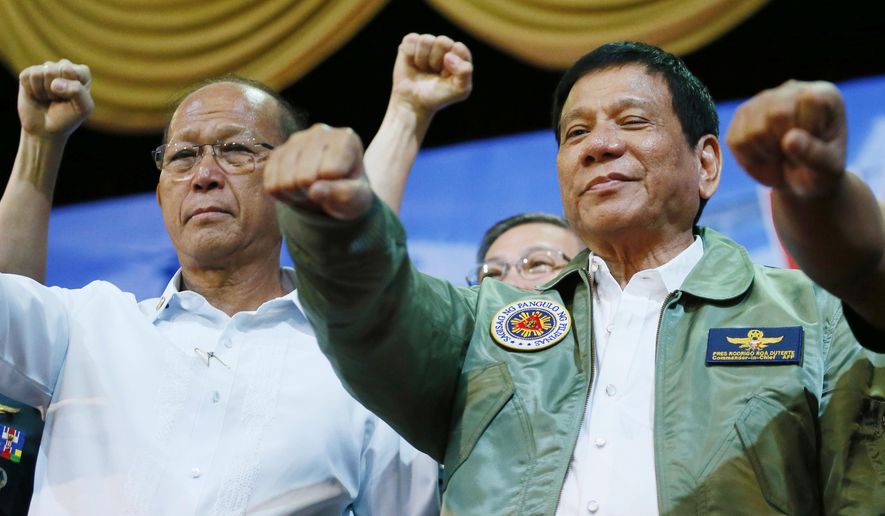 In this Sept. 13, 2016, file photo, Philippine President Rodrigo Duterte, center, poses with a fist bump with Defense Chief Delfin Lorenzana, left, during his &amp;quot;Talk with the Airmen&amp;quot; on the anniversary of the 250th Presidential Airlift Wing, at the Philippine Air Force headquarters in suburban Pasay city, southeast of Manila, Philippines. (AP Photo/Bullit Marquez, File)