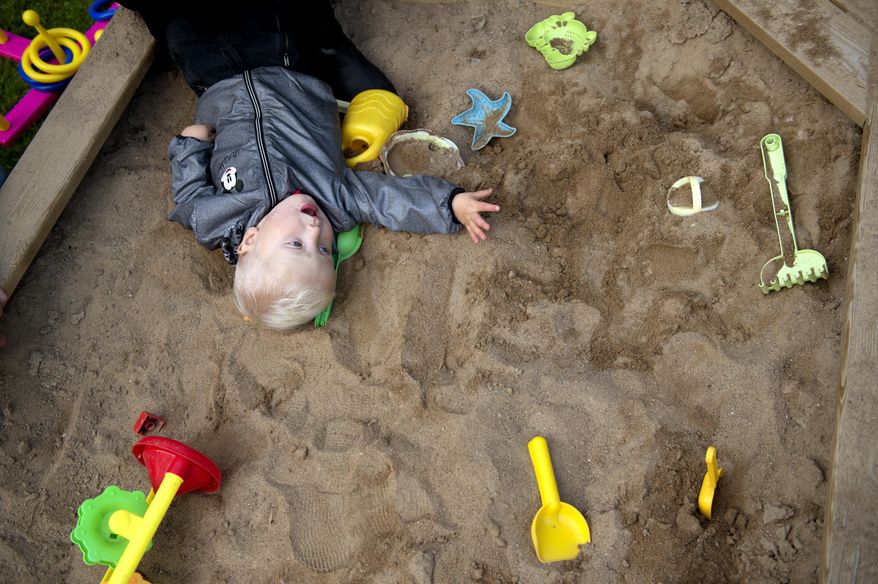 In this photo taken Tuesday, Sept. 20, 2016, Emelie Eriksson's son Albin plays at the sand pit outside their home in Bergshamra, Sweden. Eriksson was the first woman to have a baby after receiving a womb transplant from her mother, a revolutionary operation that links three generations of their family. (AP Photo/ Niklas Larsson)