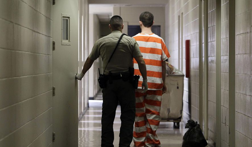 FILE - In this Feb. 21, 2013, file photo, an inmate at the Madera County, Calif., Jail is taken to an inmate housing unit in Madera, Calif. Gov. Jerry Brown dramatically altered California’s criminal sentencing system when he was first governor a generation ago. Now, with Proposition 57, he is asking voters to change it back, to give corrections and parole officials more say in when criminals are released, and strip prosecutors of the power to decide when juveniles should be tried as adults to rein in a legal code he believes has tilted too far in favor of get-tough policies. (AP Photo/Rich Pedroncelli, File)