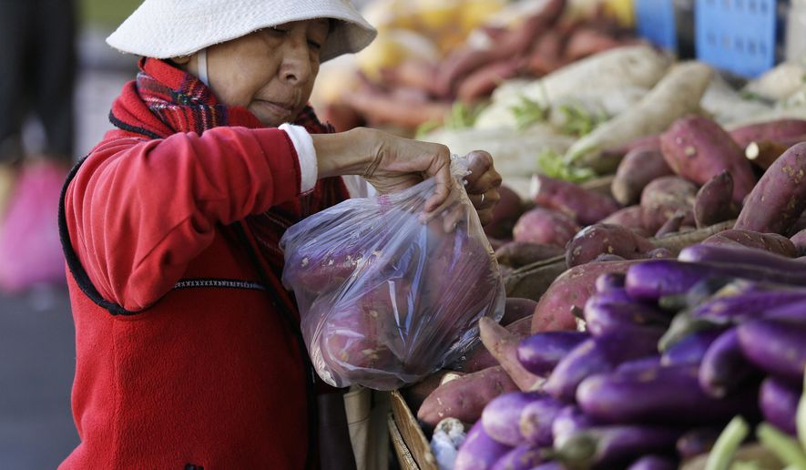 In this photo taken Tuesday, Sept. 20, 2016, a woman fills a plastic bag with potatoes at a Chinatown produce stand in San Francisco. California voters are considering a November referendum that would uphold or overturn a statewide ban on single-use plastic carryout bags, and another ballot initiative that would require fees collected from retail customers for alternative bags be put in an environmental fund. In 2007, San Francisco banned plastic shopping bags, setting off a movement that’s led to nearly half the state and its biggest cities to do the same. (AP Photo/Eric Risberg)
