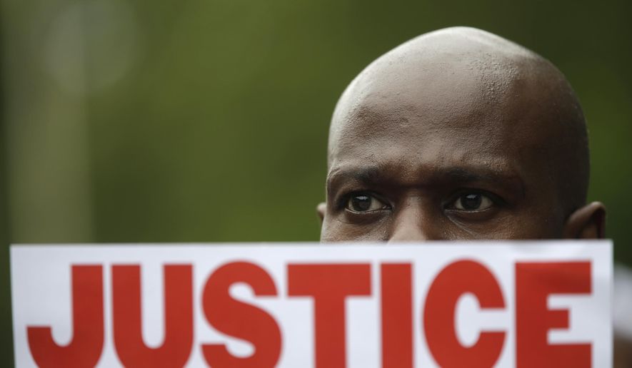 FILE - In this July 18, 2015 file photo, a demonstrator holds a sign calling for justice during a rally in New York were several hundred people rallied outside the federal courthouse in Brooklyn to demand action in the fatal chokehold death of Eric Garner by a white police officer. The proceedings to discipline NYPD police officers technically are open to the public but, because of a recent legal position taken by the city, the outcomes are withheld, a contradiction critics say is indicative of an administrative justice system that lacks enough transparency to give people confidence that the department does enough to police its own. (AP Photo/Mary Altaffer, File)