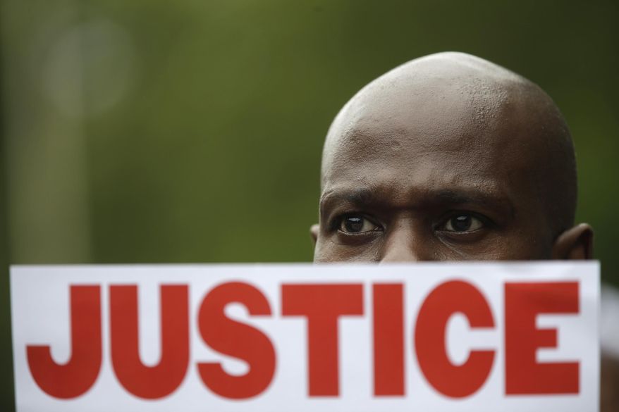 FILE - In this July 18, 2015 file photo, a demonstrator holds a sign calling for justice during a rally in New York were several hundred people rallied outside the federal courthouse in Brooklyn to demand action in the fatal chokehold death of Eric Garner by a white police officer. The proceedings to discipline NYPD police officers technically are open to the public but, because of a recent legal position taken by the city, the outcomes are withheld, a contradiction critics say is indicative of an administrative justice system that lacks enough transparency to give people confidence that the department does enough to police its own. (AP Photo/Mary Altaffer, File)