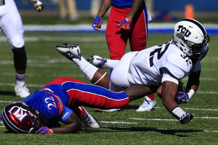 TCU linebacker Travin Howard (32) is knocked down by Kansas running back Ke'aun Kinner (22) after an interception during the first half of an NCAA college football game in Lawrence, Kan., Saturday, Oct. 8, 2016. (AP Photo/Orlin Wagner)