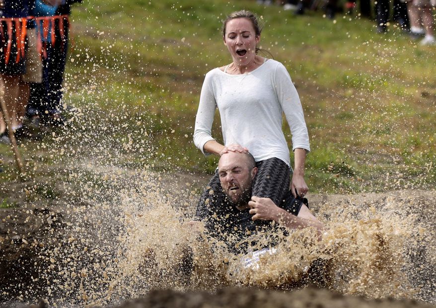 Peter Ver Ploeg carries Virginia Petrovek through the mud pit during the North American Wife Carrying Championship, Saturday, Oct. 8, 2016, at the Sunday River Ski Resort in Newry, Maine. The couple, from Portland, Maine, has been married for one year. (AP Photo/Robert F. Bukaty)