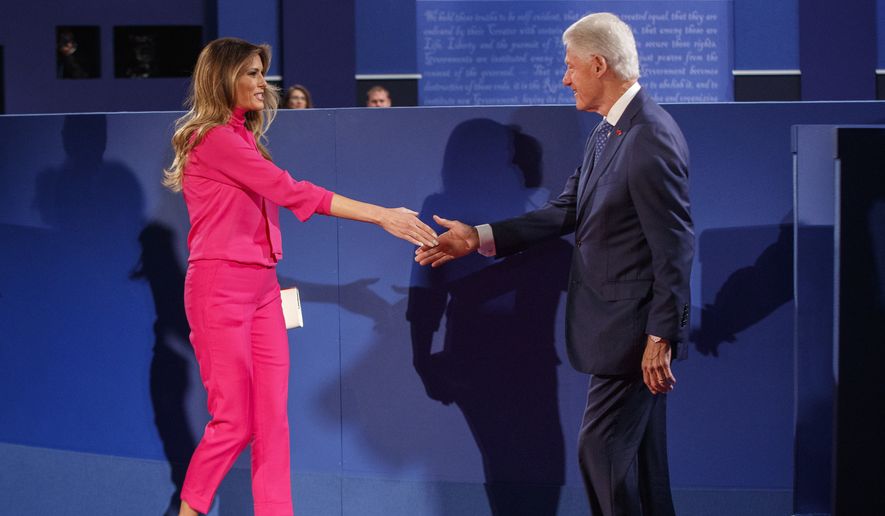 Melania Trump, wife of Republican presidential candidate Donald Trump, left, and former President Bill Clinton, husband of Democratic presidential candidate Hillary Clinton shake hands before the beginning of the second presidential debate at Washington University, Sunday, Oct. 9, 2016, in St. Louis. (AP Photo/ Evan Vucci)