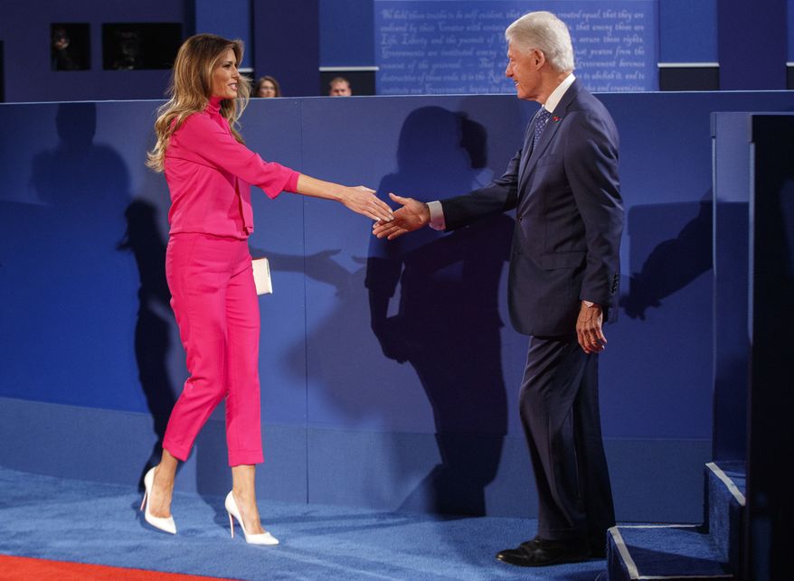 Melania Trump, wife of Republican presidential candidate Donald Trump, left, and former President Bill Clinton, husband of Democratic presidential candidate Hillary Clinton shake hands before the beginning of the second presidential debate at Washington University, Sunday, Oct. 9, 2016, in St. Louis. (AP Photo/ Evan Vucci)
