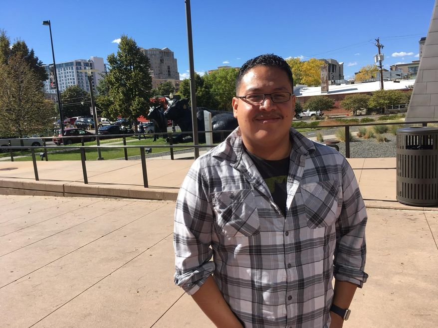 Tito Marcos, a system administrator for a Denver firm, stands outside the Denver Art Museum during his lunch break on Monday, Oct. 10, 2016. A registered independent, Marcos says he is tired of the drama of a presidential campaign, which he compared to "a heavyweight wrestling match." He's leaning toward voting for a third-party candidate. (AP Photo/Jim Anderson)