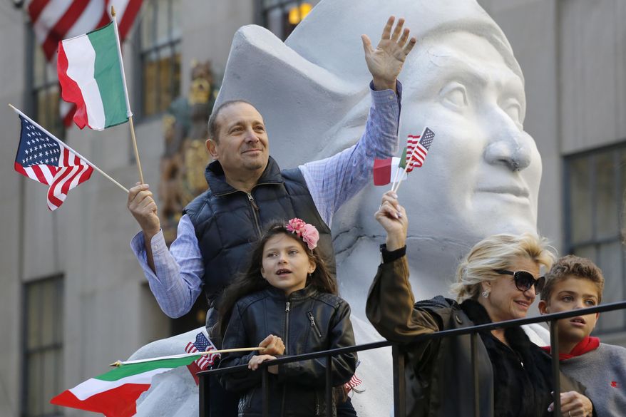 People waving Italian and American flags ride a float in the Columbus Day Parade, Monday, Oct. 10, 2016, in New York. (AP Photo/Mark Lennihan)