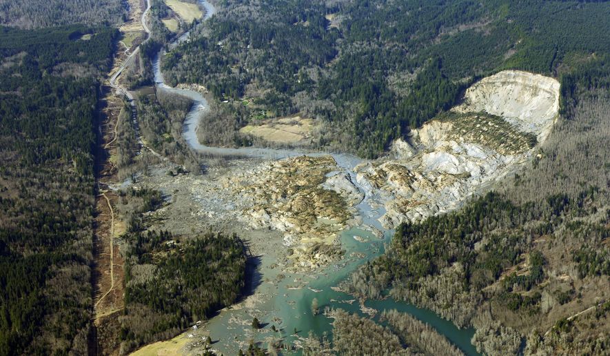 FILE - In this March 24, 2014, file photo, the massive mudslide that killed 43 people in the community of Oso, Wash., is viewed from the air. Survivors and family members of people who died in the 2014 landslide north of Seattle, Wash., have reached a tentative deal with a timber company that logged an area above the site of the collapse it was announced Monday, Oct. 10, 2016. (AP Photo/Ted S. Warren, File)