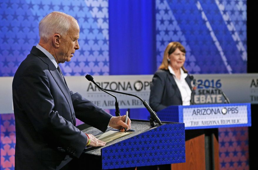 Incumbent Republican Sen. John McCain, left, takes a few notes as Arizona Democratic Rep. Ann Kirkpatrick speaks to the debate moderators prior to their only scheduled debate Monday, Oct. 10, 2016, in Phoenix before next month's general election. (AP Photo/Ross D. Franklin)