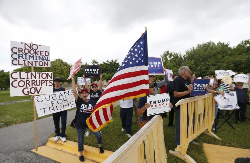 Supporters of Republican presidential candidate Donald Trump demonstrate outside a rally for Democratic presidential candidate Hillary Clinton, and former vice president Al Gore, Tuesday, Oct. 11, 2016, in Miami. During the event, Clinton will emphasizing her plans to develop more clean energy, reduce fossil fuel production and build more weather-resistant infrastructure. (AP Photo/Wilfredo Lee)